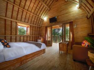 a bedroom with a bed in a room with wooden walls at Wisnu Lumbung Uluwatu in Uluwatu +37 photos