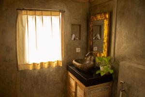 a bathroom with a sink and a mirror at Wisnu Lumbung Uluwatu in Uluwatu