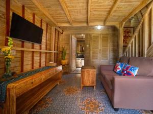 a living room with a couch and a flat screen tv at Wisnu Lumbung Uluwatu in Uluwatu