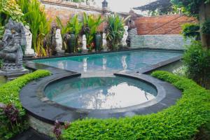 a swimming pool in a garden with plants at Wisnu Lumbung Uluwatu in Uluwatu