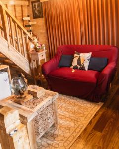 a living room with a red couch and a table at Wisnu Lumbung Uluwatu in Uluwatu