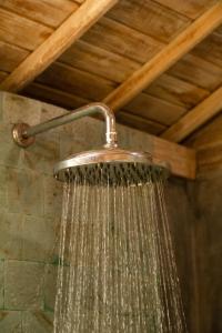 a shower head with water dripping from it in a bathroom at Wisnu Lumbung Uluwatu in Uluwatu