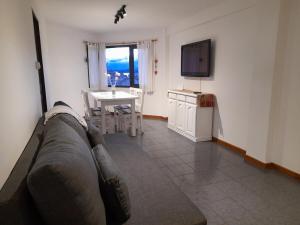 a living room with a couch and a table and a television at Super céntrico y con espectacular VISTA AL LAGO in San Carlos de Bariloche