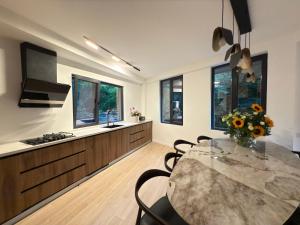 a kitchen with a table with a vase of flowers at Kvariati House in Kvariati