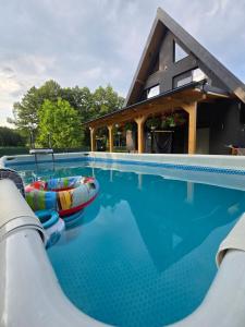 a swimming pool with two inflatable boats in the water at Căsuța din Zăvoi in Sânâteşti
