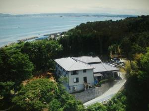 una vista aerea di una casa vicino all'acqua di 旅館青柳 海越し立山連峰の雪山絶景で休もう a Himi