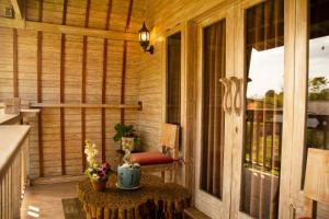 a screened in porch with a table and a chair at Wisnu Lumbung Uluwatu in Uluwatu