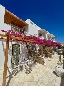 a patio with chairs and flowers on a building at Aegeo Inn in Antiparos