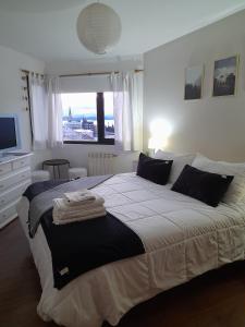 a bedroom with a large bed with a large window at Super céntrico y con espectacular VISTA AL LAGO in San Carlos de Bariloche