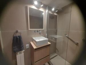 a bathroom with a sink and a mirror and a shower at Super céntrico y con espectacular VISTA AL LAGO in San Carlos de Bariloche +50 photos