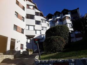 a large white building with a bush in front of it at Super céntrico y con espectacular VISTA AL LAGO in San Carlos de Bariloche