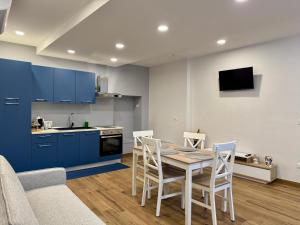 a kitchen with blue cabinets and a table and chairs at Petranera Apartment in Randazzo