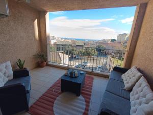 a balcony with couches and a view of a city at le contemporain in Bastia