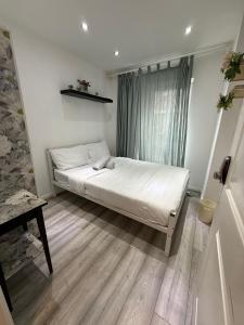 a small bedroom with a bed and a window at Property Near Canary Wharf in London