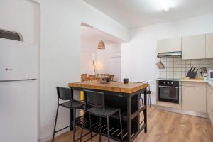a kitchen with a island in the middle of a room at Stylish 2BR Apartment with Rooftop Pool in Mackenzie in Larnaca