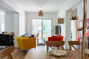 a living room with colorful chairs and a table at Stylish 2BR Apartment with Rooftop Pool in Mackenzie in Larnaca +13 photos