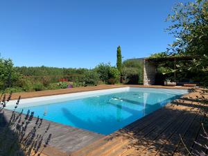 a swimming pool with blue water in a yard at Le séchoir de Valadon in Aillas