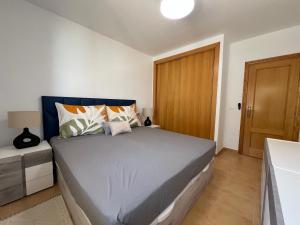 a bedroom with a bed and a wooden door at Cosy Apartment in a Secured Compound of PlayaSol with Large Pools in Vinaròs