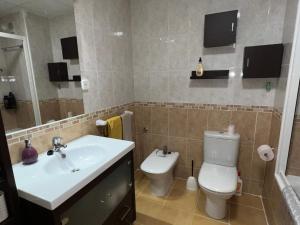 a bathroom with a sink and a toilet and a television at Cosy Apartment in a Secured Compound of PlayaSol with Large Pools in Vinaròs