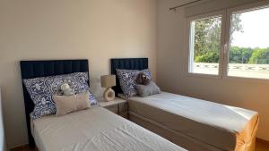 a bedroom with two beds next to a window at Cosy Apartment in a Secured Compound of PlayaSol with Large Pools in Vinaròs +4 photos