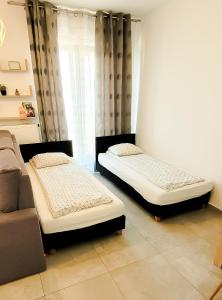 two beds sitting in a room with a couch at Rent-Apart City Center Narutowicza in Łódź