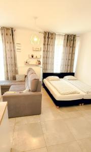 a living room with two beds and a couch at Rent-Apart City Center Narutowicza in Łódź