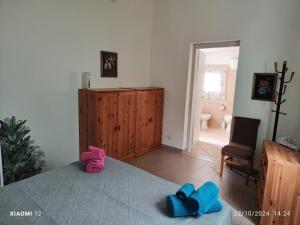 a bedroom with a bed with blue and pink towels on it at Mambo House in Sarroch