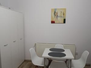 a white table and white chairs in a room at Spital 1 camera in Târgu-Mureş