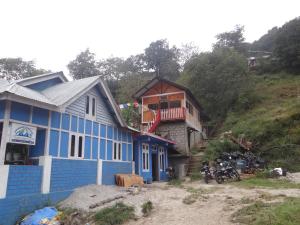 una casa blu seduta in cima a una collina di Sangti Valley Ngoedrup Wooden Cottage a Dirang Dzong