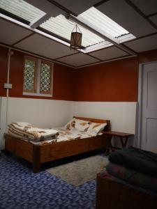 una camera con un grande letto e un lucernario di Sangti Valley Ngoedrup Wooden Cottage a Dirang Dzong