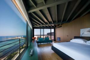 una camera con un grande letto e una grande finestra di Hotel Punta Tipa a Trapani