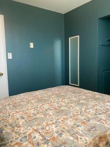 a bedroom with a large bed in a blue wall at The Gateway Suite in Fortune +26 photos
