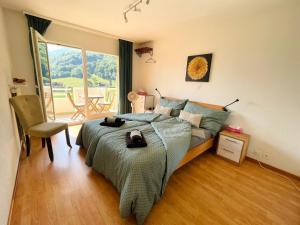 a bedroom with a bed and a large window at Mountain View in Monthey