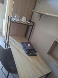 a small room with a shelf with a remote control on it at Hôtel des 2 Gares in Nevers