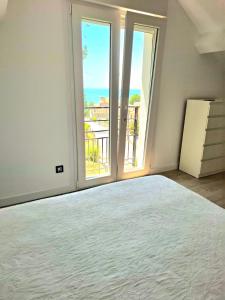 a bedroom with a large bed and a large window at Apartamentos Mar de Nanín in Sanxenxo