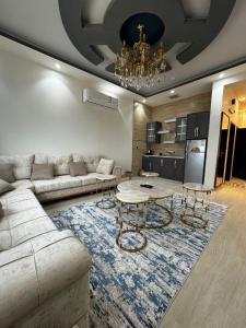 a living room with a couch and a table at فوج فيو للفلل والشقق الفندقية in Al Namas