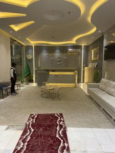 a lobby with a piano and a red rug at فوج فيو للفلل والشقق الفندقية in Al Namas