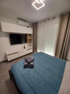 a bedroom with a bed with a blue comforter and a television at Appartement au cœur de Calvi,a 150 m de la plage in Calvi