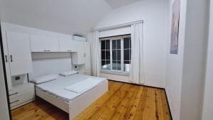a white room with a bed and a window at The Pearl of Gabala in Gabala