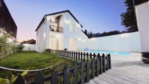 a white house with a fence and a swimming pool at The Pearl of Gabala in Gabala +21 photos
