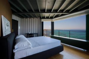 a bedroom with a bed and a view of the ocean at Hotel Punta Tipa in Trapani