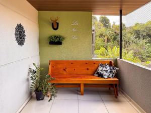 a wooden bench sitting on the side of a balcony at Casa espaçosa com 3 quartos | Até 11 pessoas in Limeiro