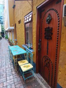 a table and chairs next to a building with a door at Cabaña tipo loft in Usaquén