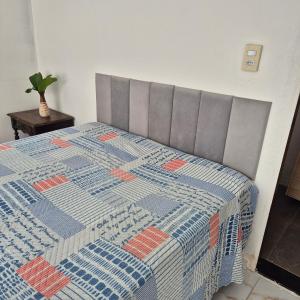 ein Bett mit einer Decke in einem Schlafzimmer in der Unterkunft Chácara Corujá in Juazeiro do Norte