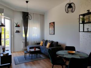 a living room with a blue couch and a table at Lake Palić Apartment in Palić