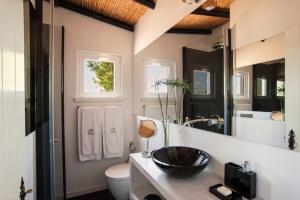 a bathroom with a sink and a toilet and a mirror at Quinta da Lua in Tavira +37 photos