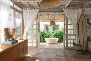 Uluwatu Lagoons - Retreat and Villas في أُلُواتو: حمام مع حوض استحمام في الغرفة