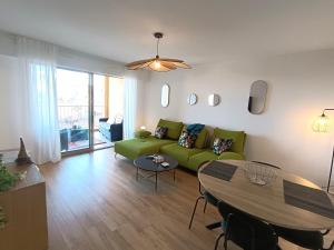 a living room with a green couch and a table at le contemporain in Bastia