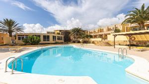 duży basen z palmami i budynkami w obiekcie Private Terrace Home - Pool - Wifi w mieście Costa Calma