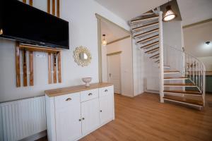 a living room with a tv and a staircase at Villa Stradivaryus in Sighetu Marmaţiei
